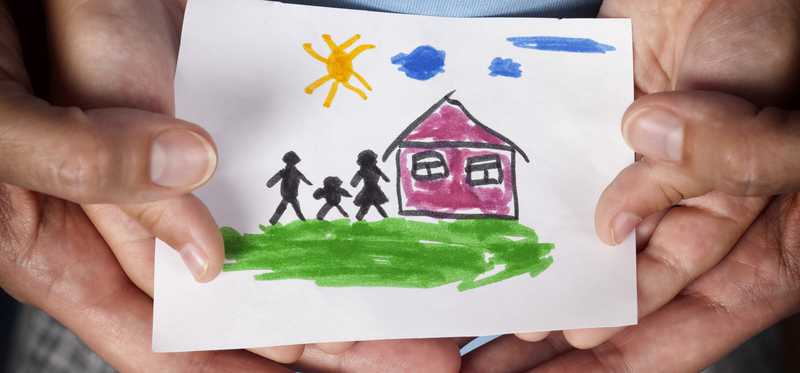 Hands holding a child's drawing.
