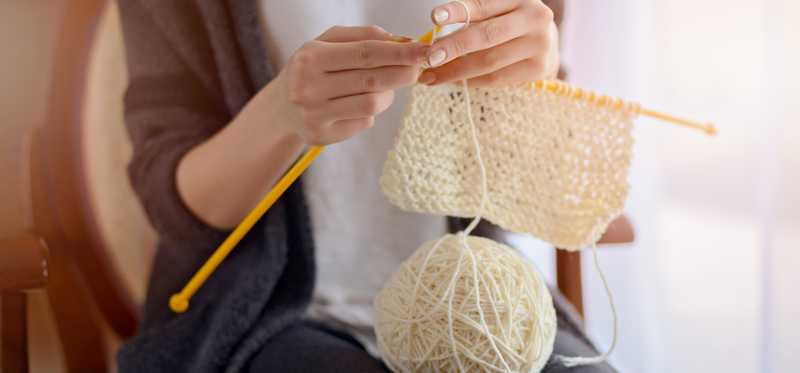 A closeup of a woman's hands as she knits