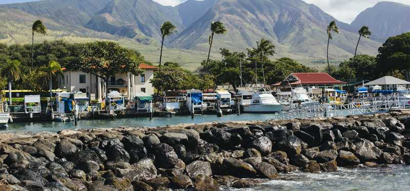 Boat slips in Lahaina, Maui, Hawaii, with the mountains rising behind them.