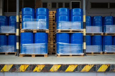 Large blue metal barrels stacked together at a loading dock.