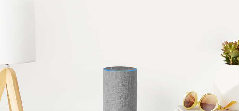 The gray Amazon Echo Dot sitting on a desk