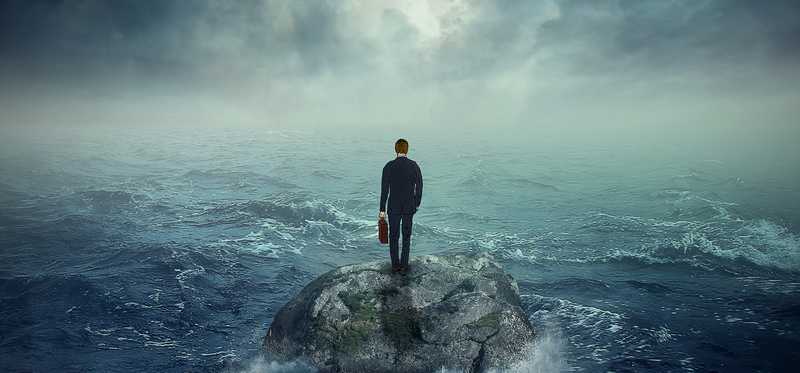 A man in a suit stands alone on an sialnd.