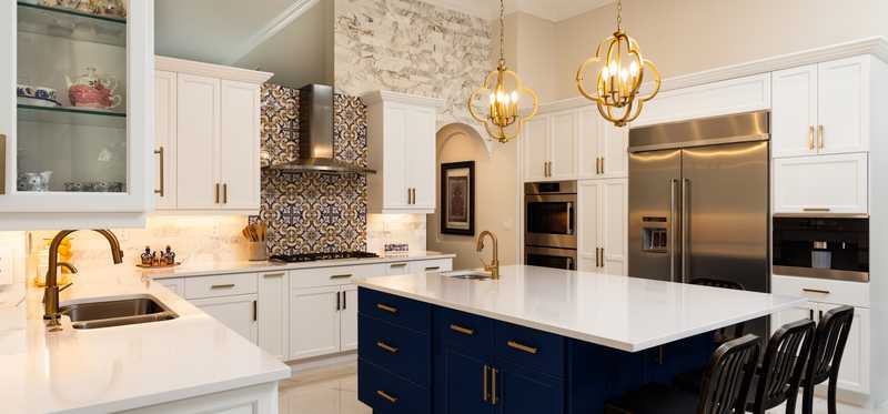 A luxury white-and-black kitchen with an island and stainless steel appliances.