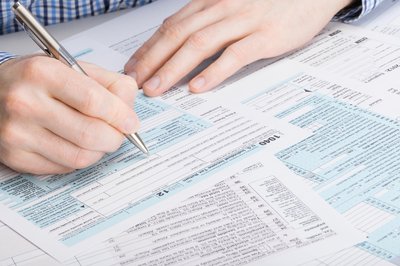 Person filling out tax form.
