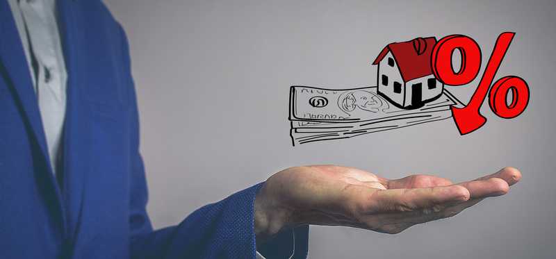 Man holding hand below illustration of home with money and a percentage sign.