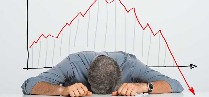 Man lying on table in front of stock chart