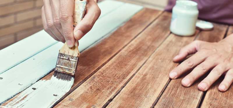 Man painting old wooden table.