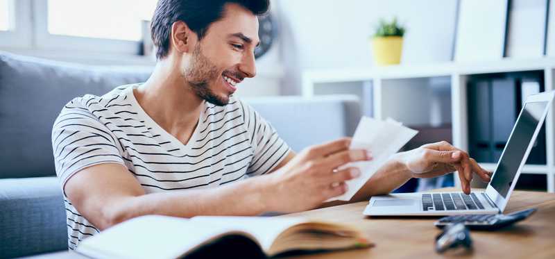 Man paying bills online from laptop