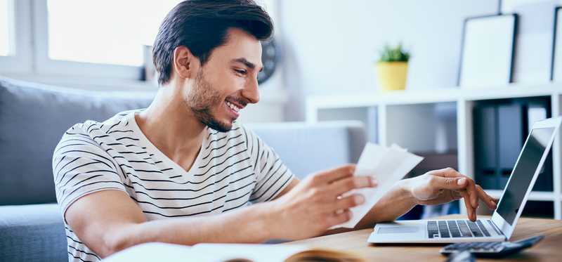 Person paying bills online from laptop.