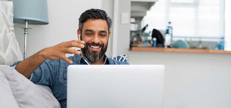 Person using laptop for video call at home.