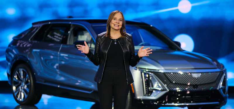 General Motors CEO Mary Barra speaking by a car.