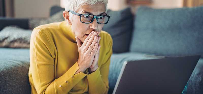 Person looking at computer in shock.