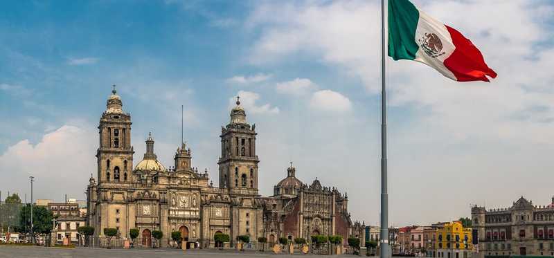 A building in Mexico with Mexican flag raised out front.