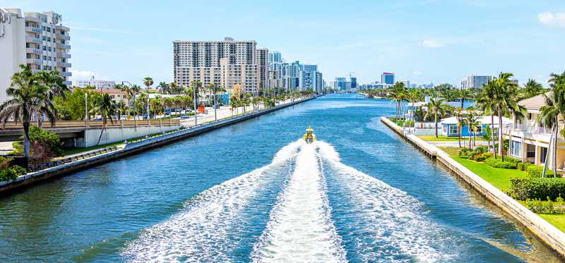 A boat being driven up a canal in Miami, Florida.