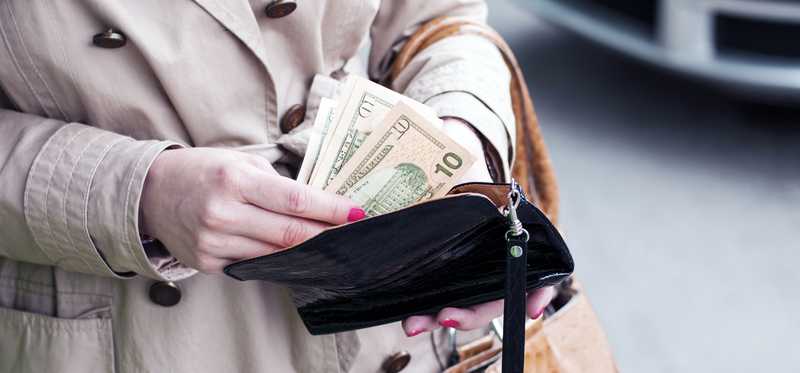 A person takes money from a wallet.