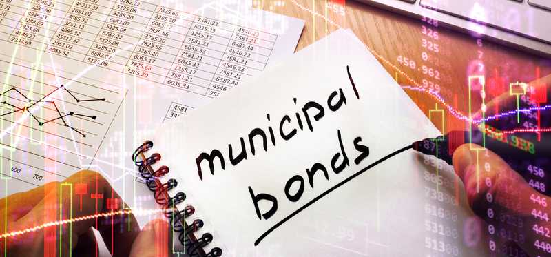 A person writing Municipal Bonds in a notebook.