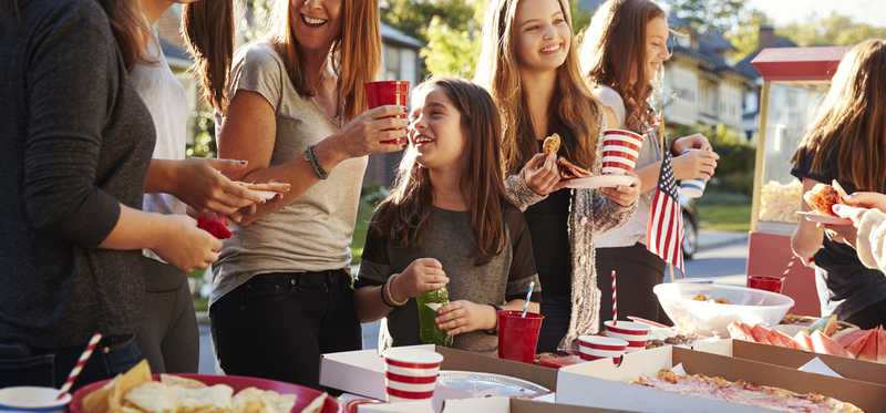 Neighbors eating food at a block party.
