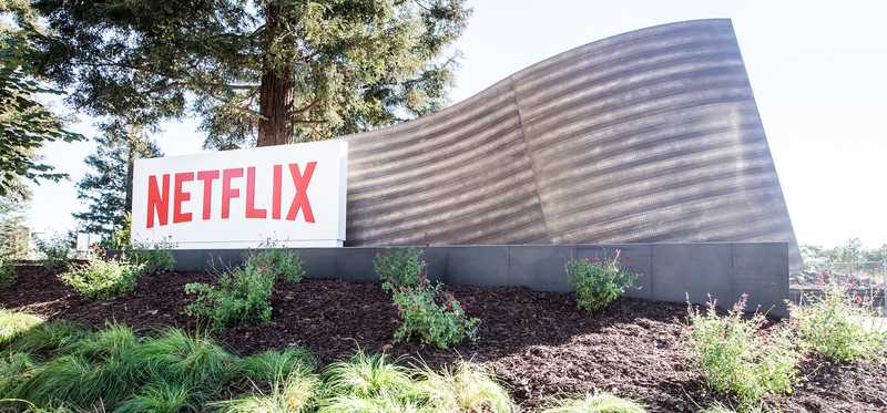 A Netflix sign outdoors in a landscaped area.