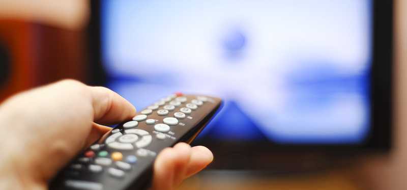 A cable remote is pointed at a big-screen television.