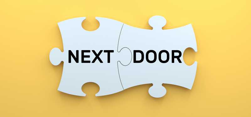 The words Next and Door on puzzle pieces fit together.