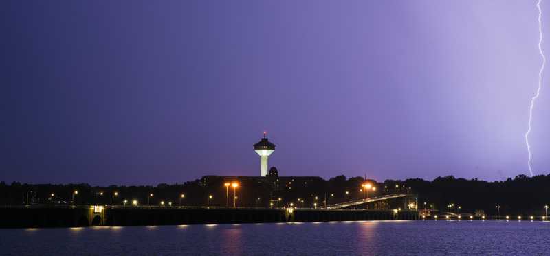 A lightning bolt strikes over a night sky in Florence, Alabama, from across the Tennessee River at Muscle Shoals.