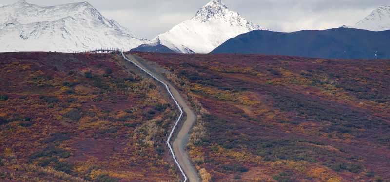 Oil pipeline cutting across a rugged mountain.