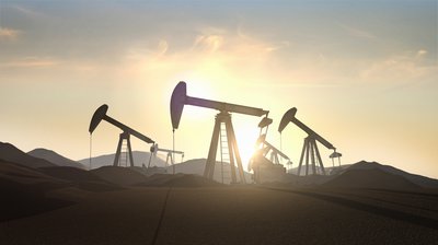 Three oil pumps in desert at sunrise.