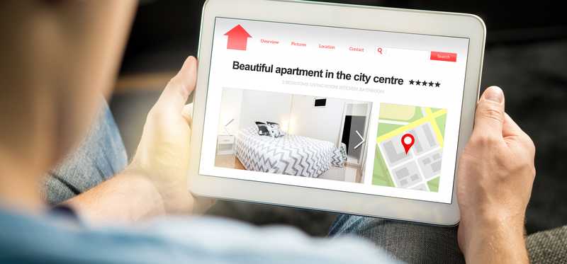 Person browsing online rental listings.
