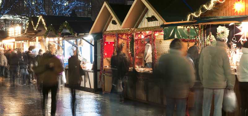 People shopping at an outdoor market at night.