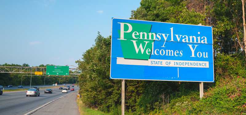 A highway road sign that says Pennsylvania Welcomes You and State of Independence.