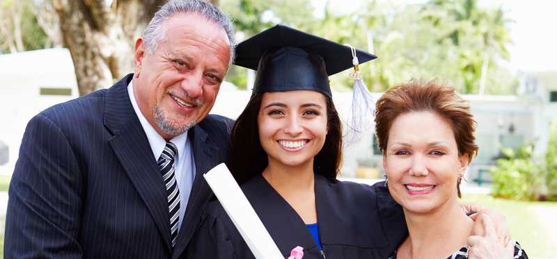 Parents with female college student at graduation in cap and gown