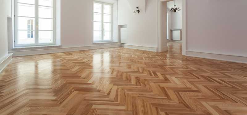 Parquet flooring in a large, empty living area.