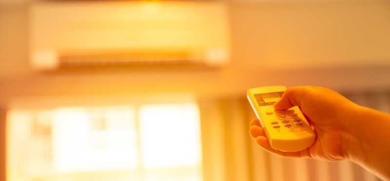 Person adjusting AC with remote