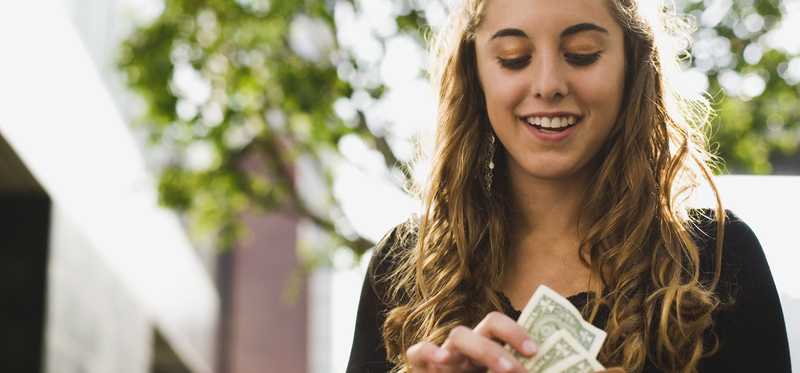 Person pulling money out of their wallet.