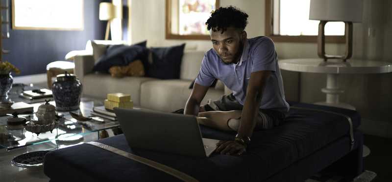 Person staring intently at laptop screen in living room.