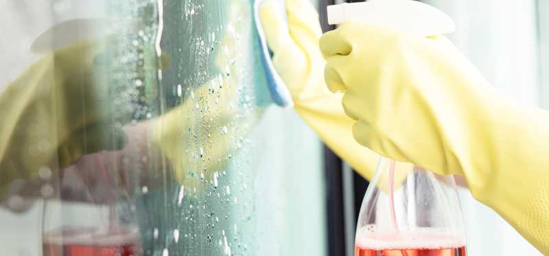 Person with gloves cleaning window.