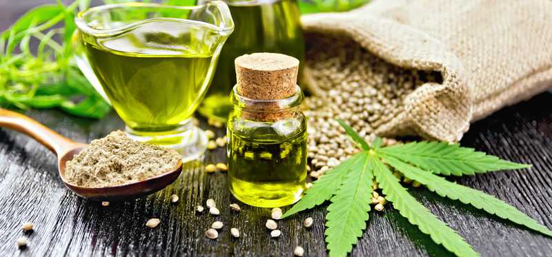 An assortment of cannabis products including oils and a marijuana leaf.