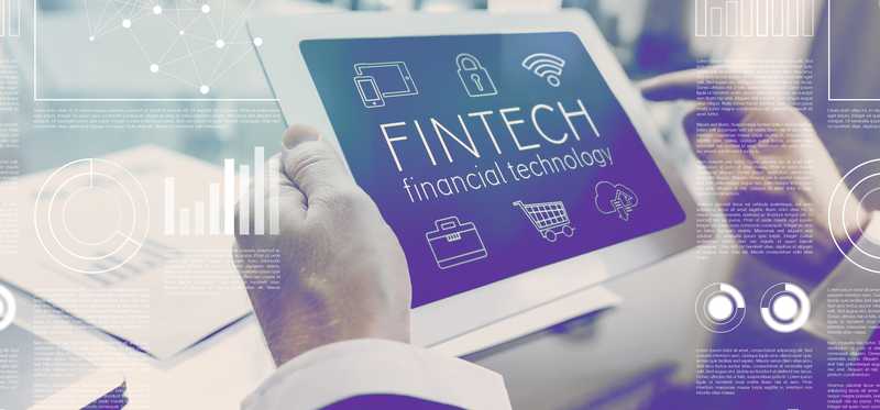 Personal holding a tablet with Fintech on the screen.