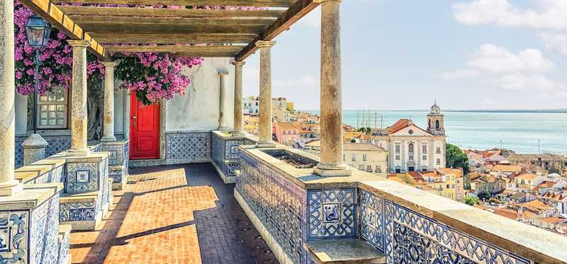 A balcony in Lisbon is overlooking the water.