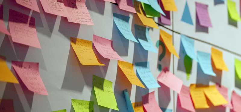 Multicolored Post-it notes on a wall.