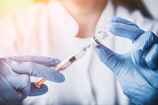 Medical personnel preparing an injection.