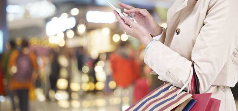 A person holds up a smartphone in a store.