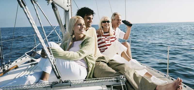 People smiling while relaxing on a yacht.