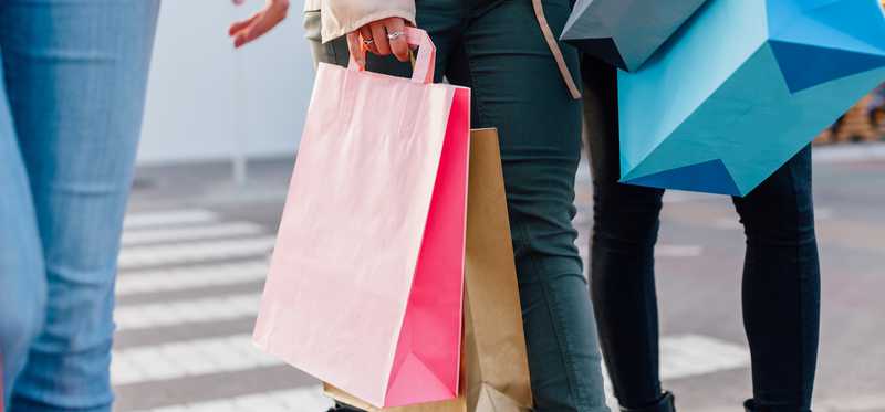 Three people holding shopping bags