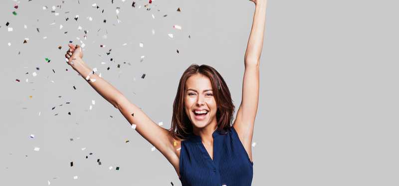 A happy woman celebrating with confetti