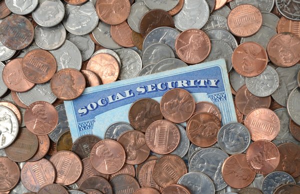 Social Security card piled with coins.
