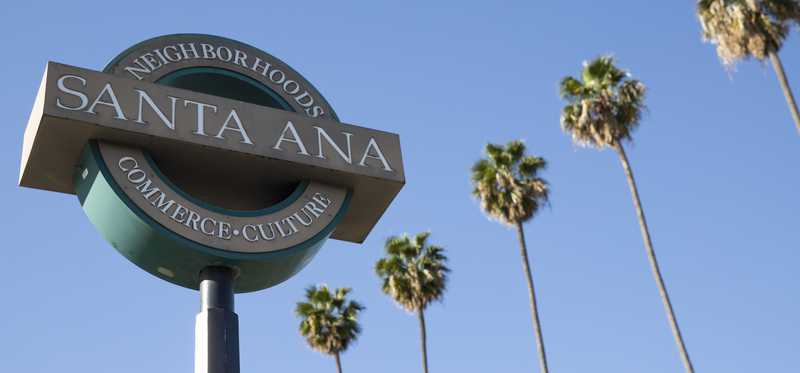 A city sign and palm tree in Santa Ana, California.