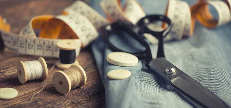 Scissors and measuring tape with article of clothing.