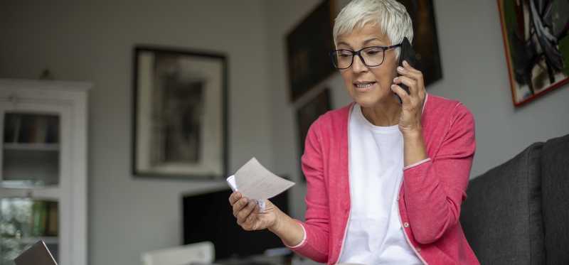 Person holding check and talking on phone.