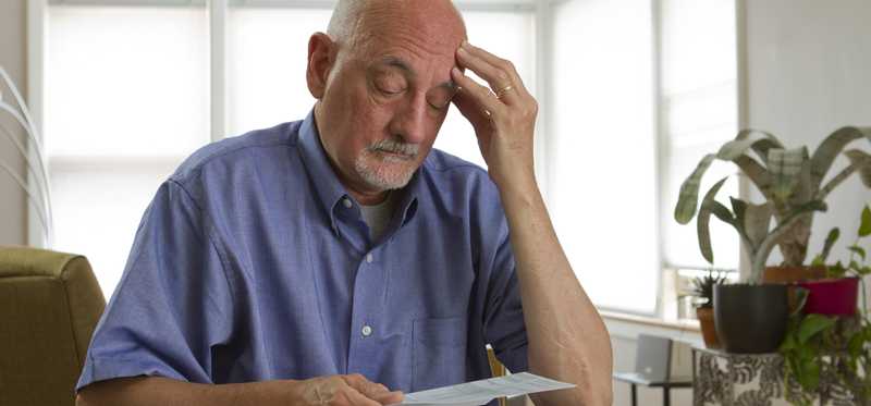 Person looking at bills worriedly.